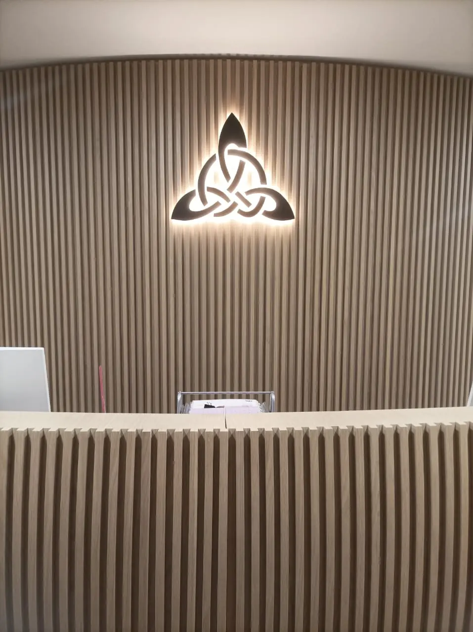A backlit logo panel made by Print Solution, glowing on a dark wall